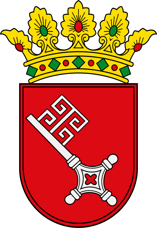 A shield with a red background decorated by a golden crown on top of it. There is a medieval white key in the main part.