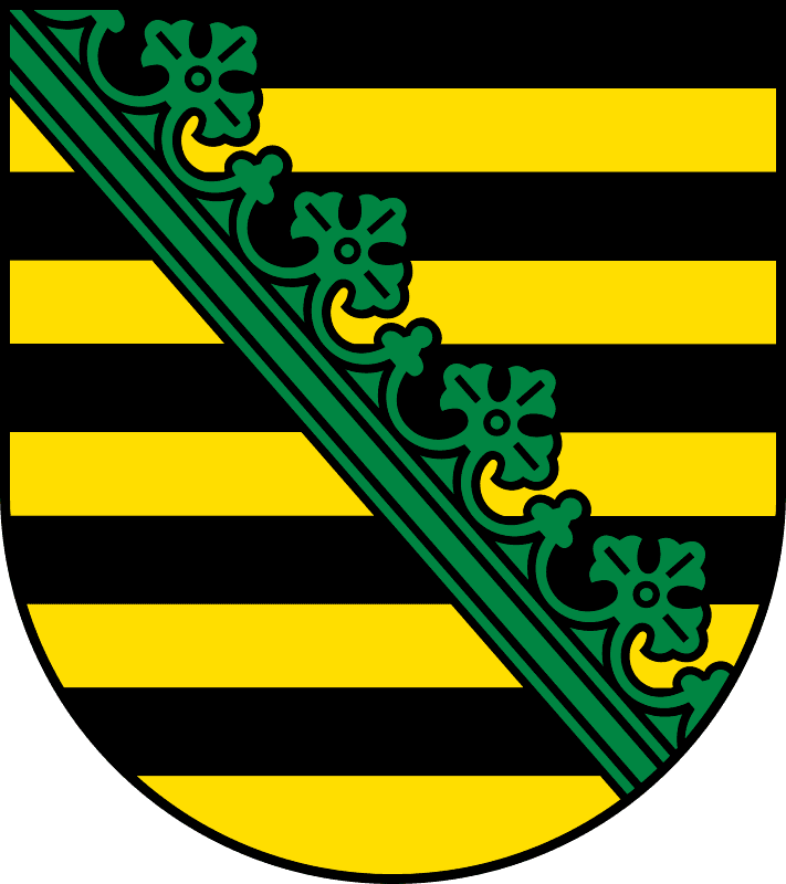A shield with black and yellow stripes (5 + 5) as a background. There is green ornament on its diagonal.
